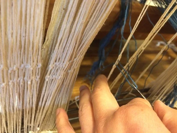 Closeup of pulling each yarn through the heddles. Make sure to alternate harnesses. 