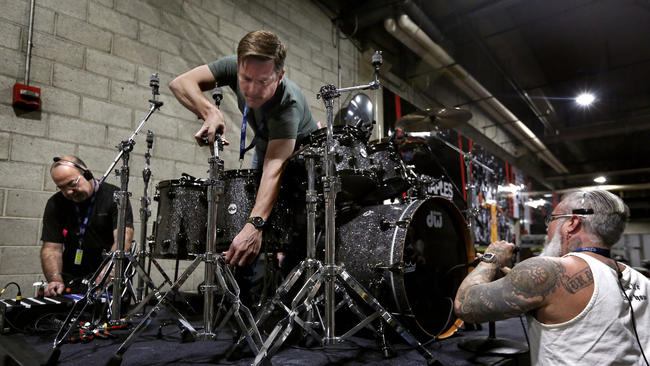 From left: Audio assistant Pete San Filipo, back line tech Ben Fenton and audio assistant Damon Andres get gear set up and check microphones on a drum riser that will be used for a performance by Lionel Richie during the Grammy Awards show. (Mel Melcon / Los Angeles Times)