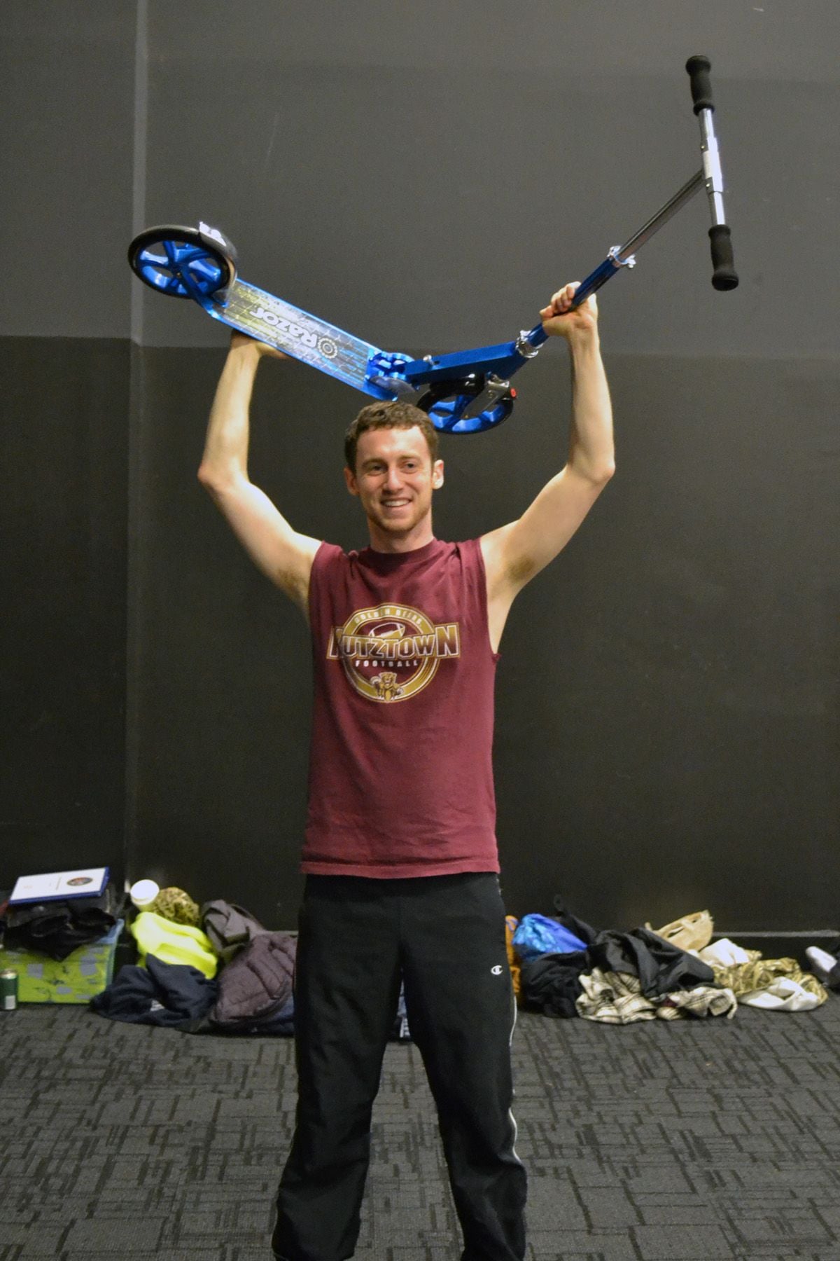 Kelly Anne Dolan Memorial Fund's Brian Mahoney holds up his racing scooter in triumph after winning the scooter race on Saturday.