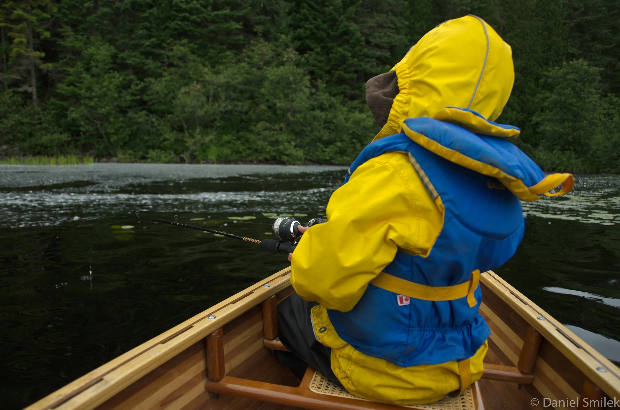 Luke wearing his rain suit while fishing on a rainy day.