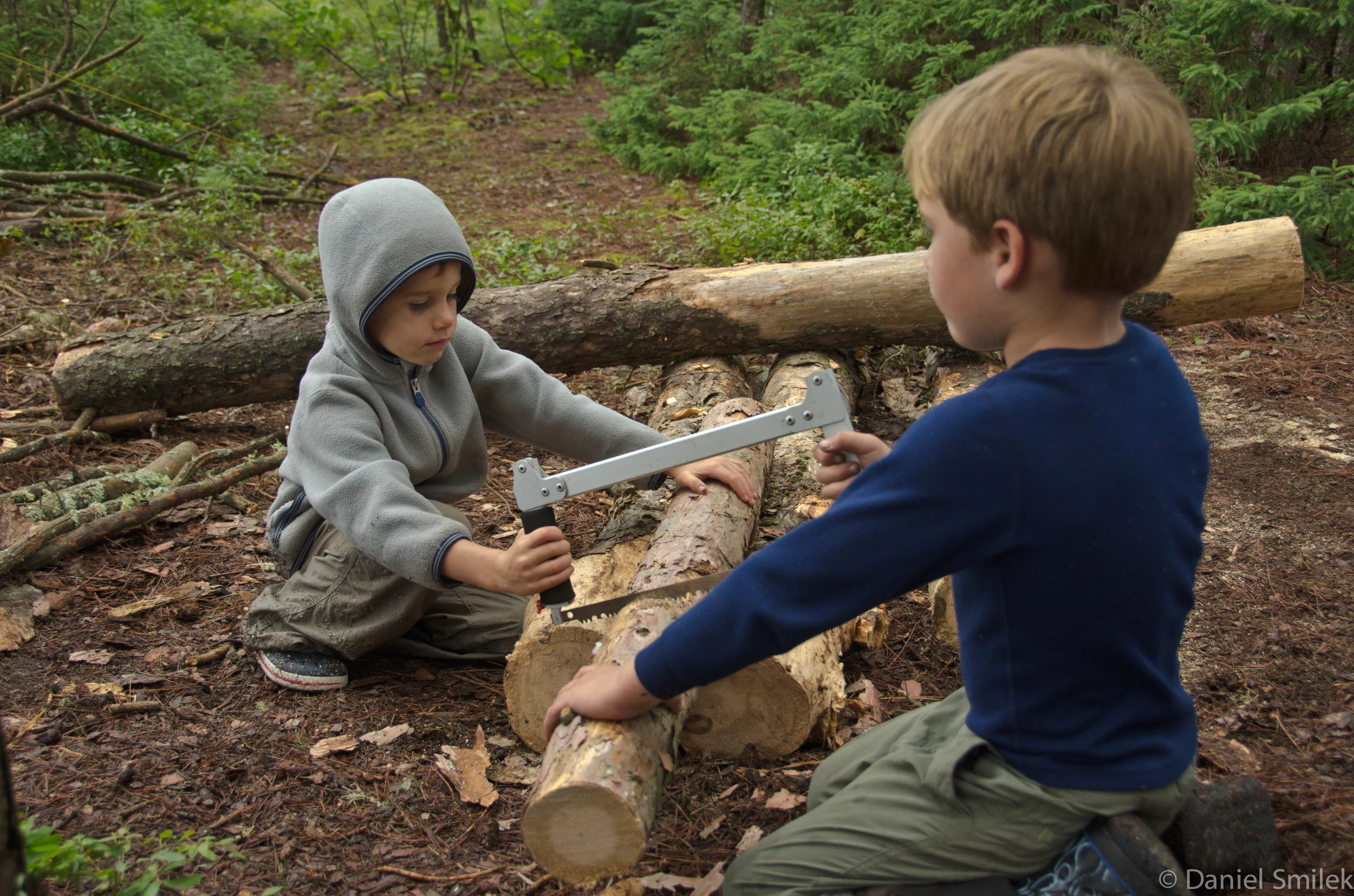 Luke (right) cutting wood with Noah (left).