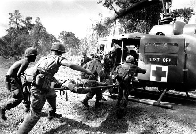n your book Page After Page , you wrote about one night in 1965 where you were stationed at an outpost with a Special Forces group. You were overrun in the middle of the night and you, personally, had to defend yourself. What's the line between combatant and observer? When it gets to that kind of situation, in the heat of battle, the enemy doesn’t have time to differentiate between you wearing a black T-shirt and a camera and the guy with the Special Forces badge on sitting next to you; he’s not going to see the difference. That kind of situation there was… I had no choice. In the heat of the battle nothing is making sense, your only thought is, I don’t want to be here , but unfortunately you can’t press a button and delete yourself from the situation. Well you can but it’s called d ead . I had been issued a weapon and a bunch of clips when I arrived and was told if the shit goes down that’s where you’re going to be, and I was there. I suppose because we’re photographers we’re not bad shots. I hit the guy with three rounds right in the chest, right where you’re supposed to. He wasn’t wearing any body armor. I have no feeling about it… I should have feeling. It was just a really bad night. I had no choice. There was no alternative. You can’t turn the clock back, you can’t alter history. I’ve lit enough incense for him, I’ve meditated on it. I’ve never had to use a weapon again. Another thing you talk about in your book is a Rolex watch you owned that would get lost each time you were hit; in one instance it was returned two years later. Do you still have that Rolex? No. A hooker in Manchester got it. I was photographing a rock group called the Happy Mondays the 70s. We went to the Hacienda and got wasted. I picked up this hooker and she ended up with the Rolex.