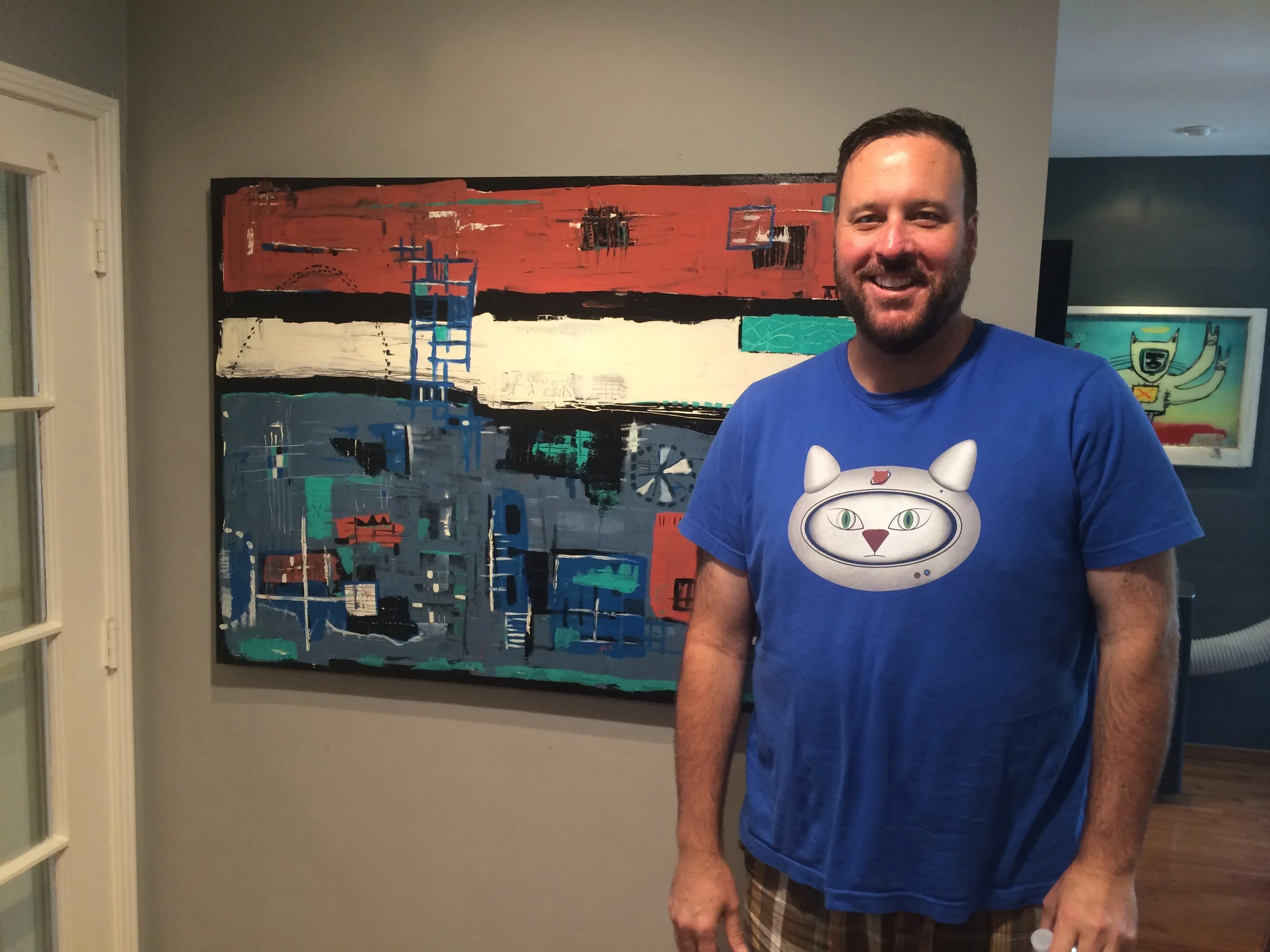Joe Dietl in front of one of his paintings. The painting to the right is also one of his.