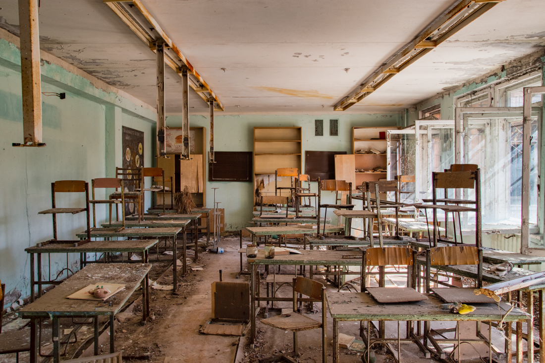 Tables and chairs stacked inside a former classroom. Image: 2015.