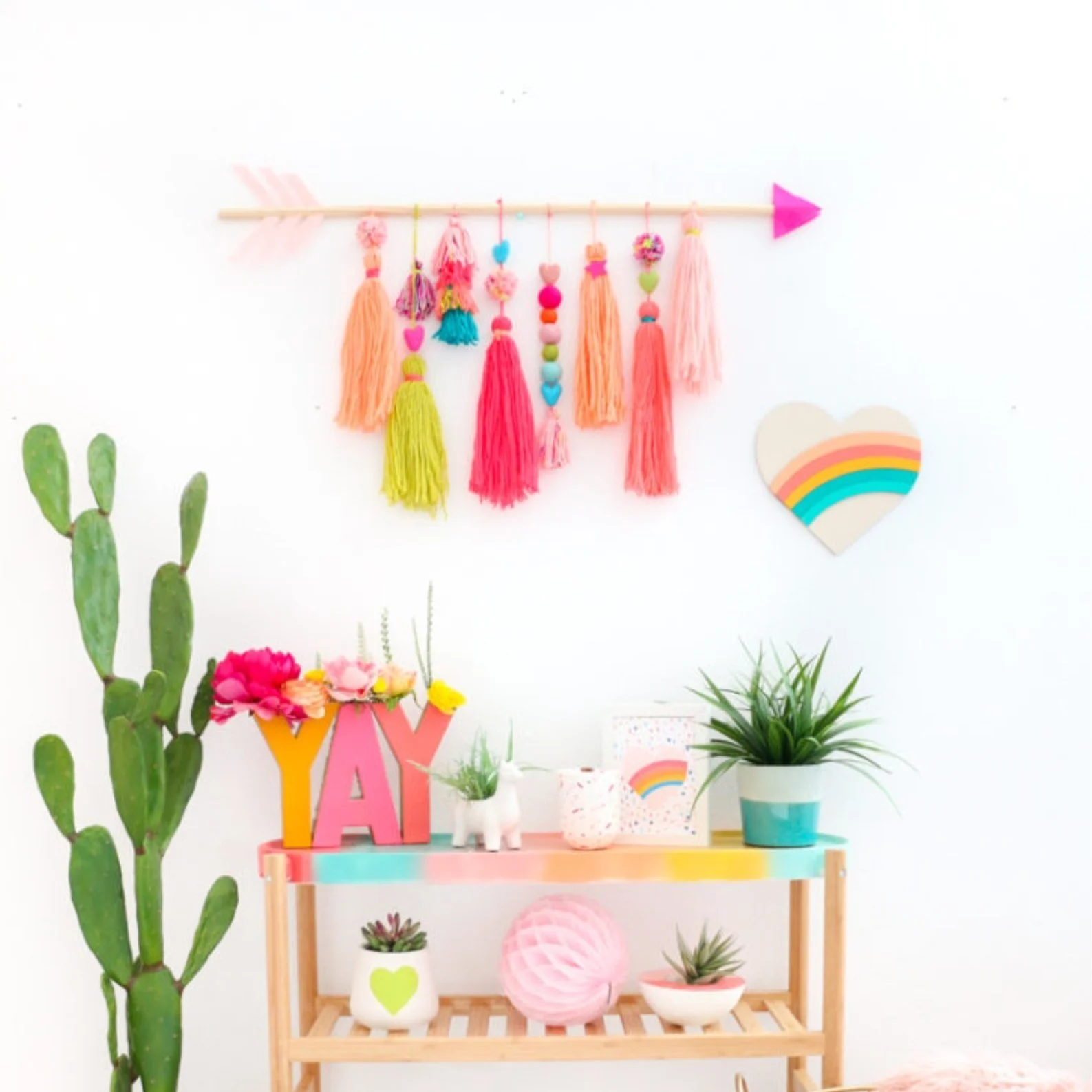 Wooden arrow wall hanging decorated with tassels.