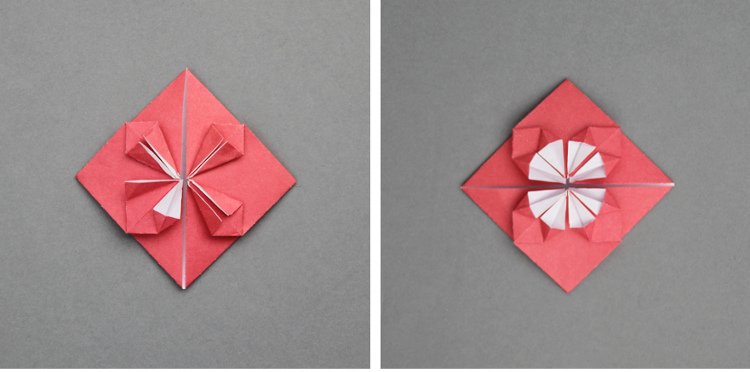 Red paper folded into diamond shape with white petal shapes in center.