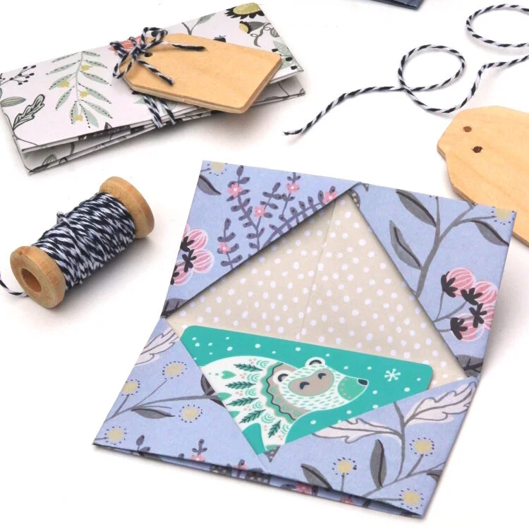origami gift card envelope with thread and wooden tags in background