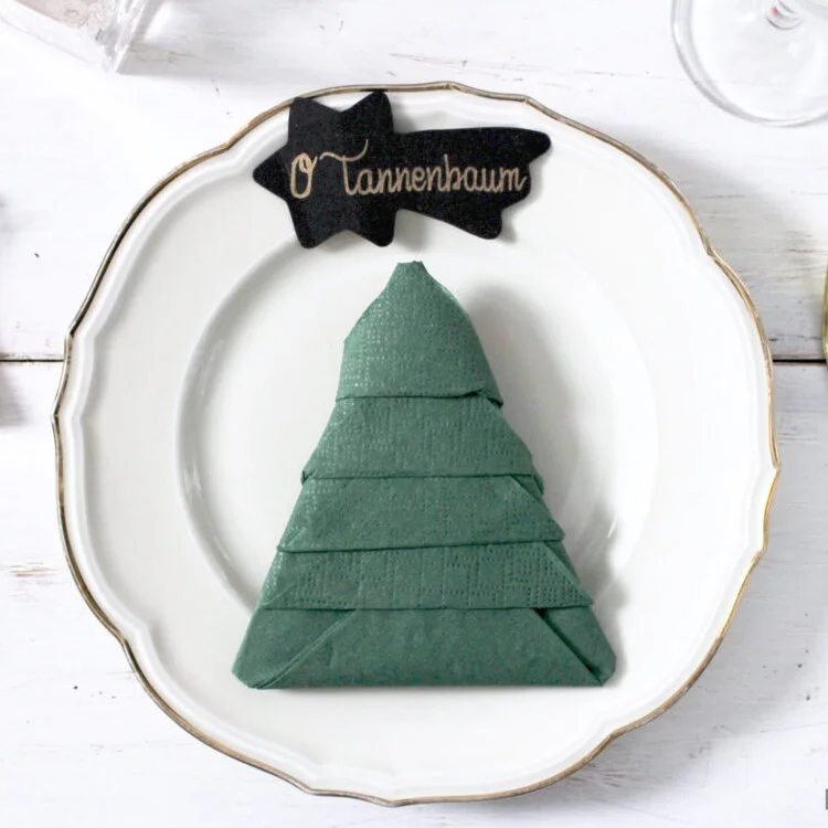 green origami napkin tree on white plate
