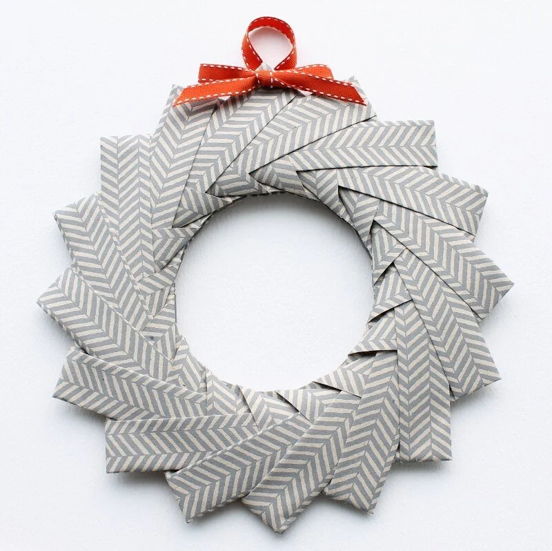 grey and white patterned paper origami wreath red bow at top