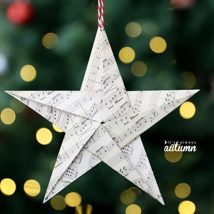 origami star hanging from thread on dark background