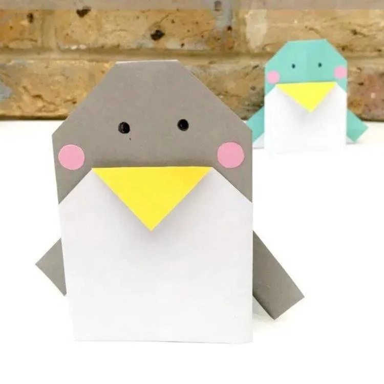 grey origami penguin with blue penguin in the background