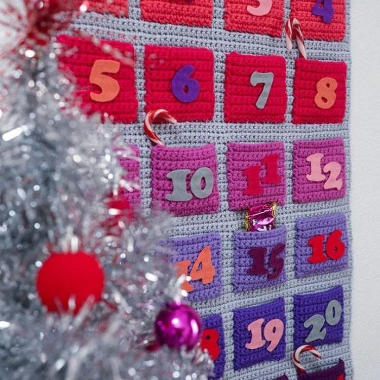 grey crochet advent calendar with red and purple numbered crochet pockets