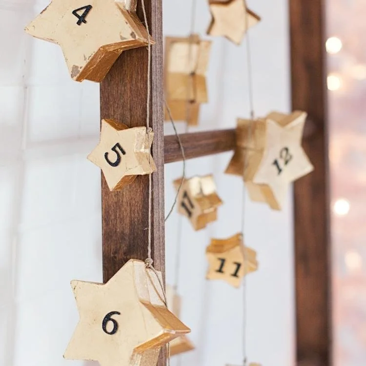 gold star boxes with black numbers hanging on wooden ladder