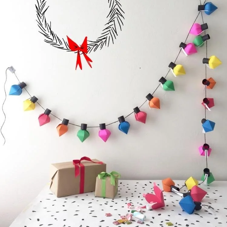 rainbow coloured paper light bulbs hanging from string