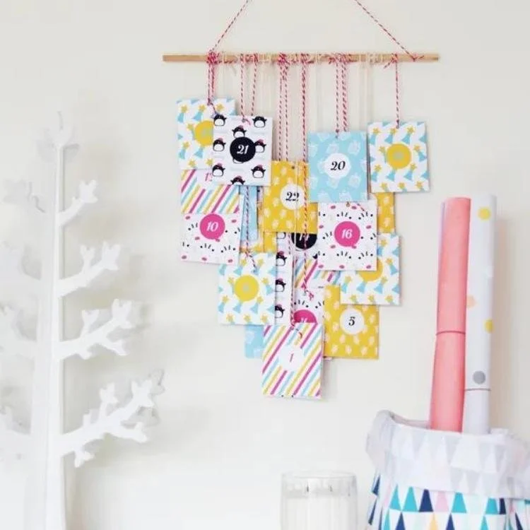 colourful envelopes with numbers on them hanging from wooden dowel