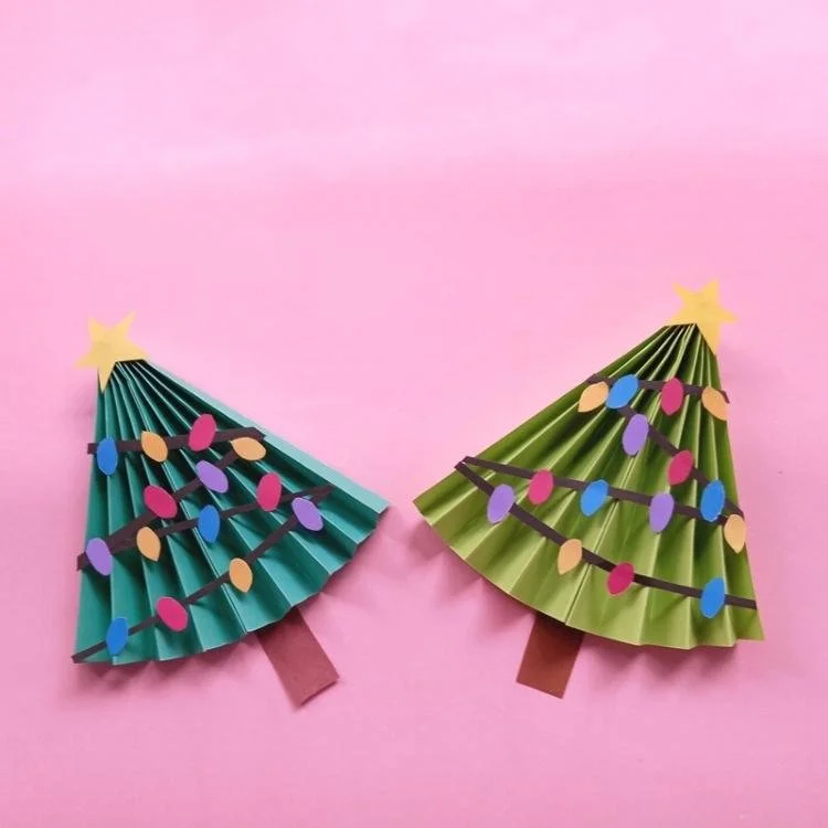 two green origami trees in fan shape covered in tiny paper lights