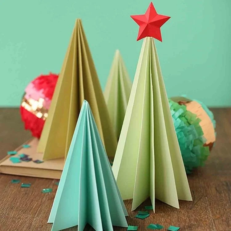 3 different sizes of green origami tree with baubles behind them