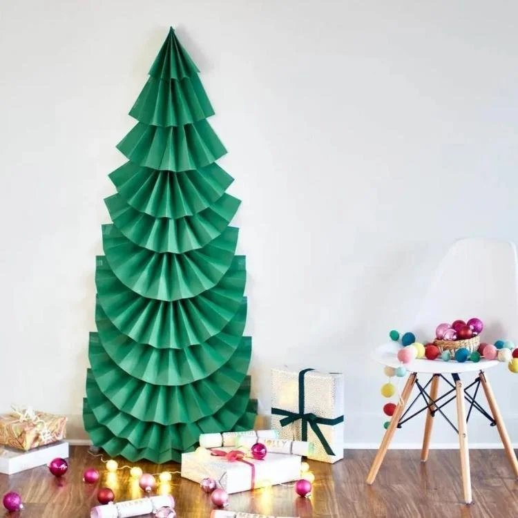 large green paper tree on wall with gifts at bottom