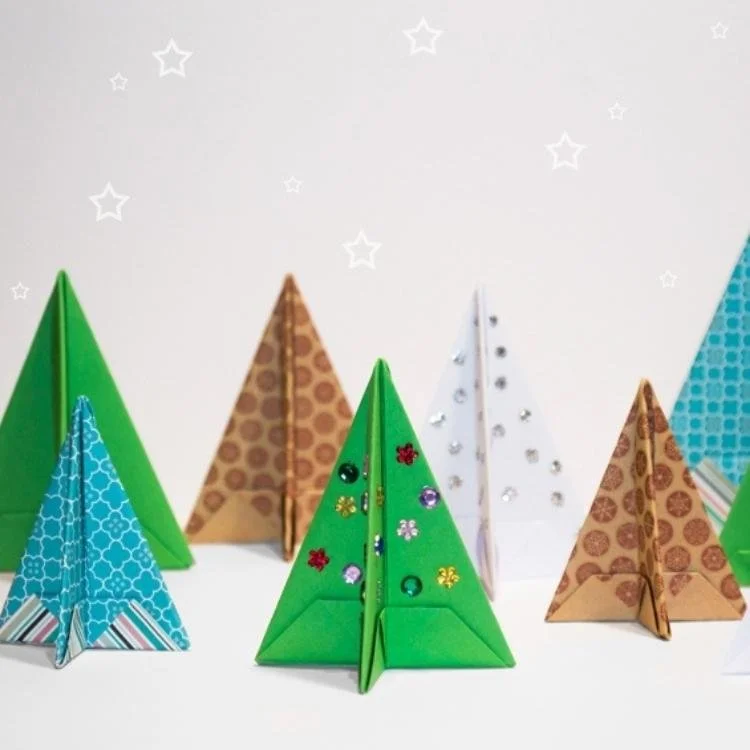seven origami christmas trees standing in two rows