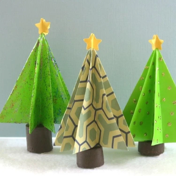 3 origami trees with yellow stars on top standing in a row