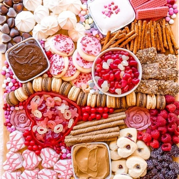 wooden board filled with heart shaped biscuits, sweets and candy