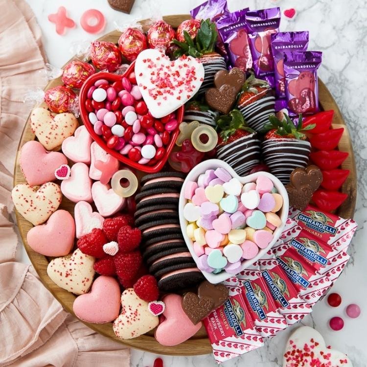 round plate filled with heart shaped sweets and chocolate covered strawberries