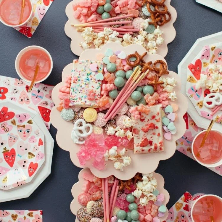 pink plates filled with pink and white candy on grey tabletop