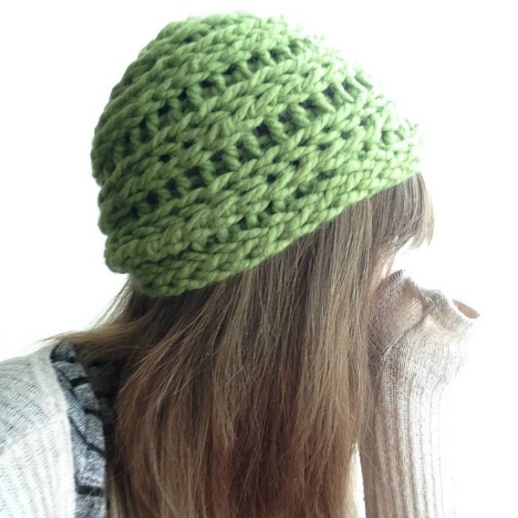 person wearing green finger knit beanie hat