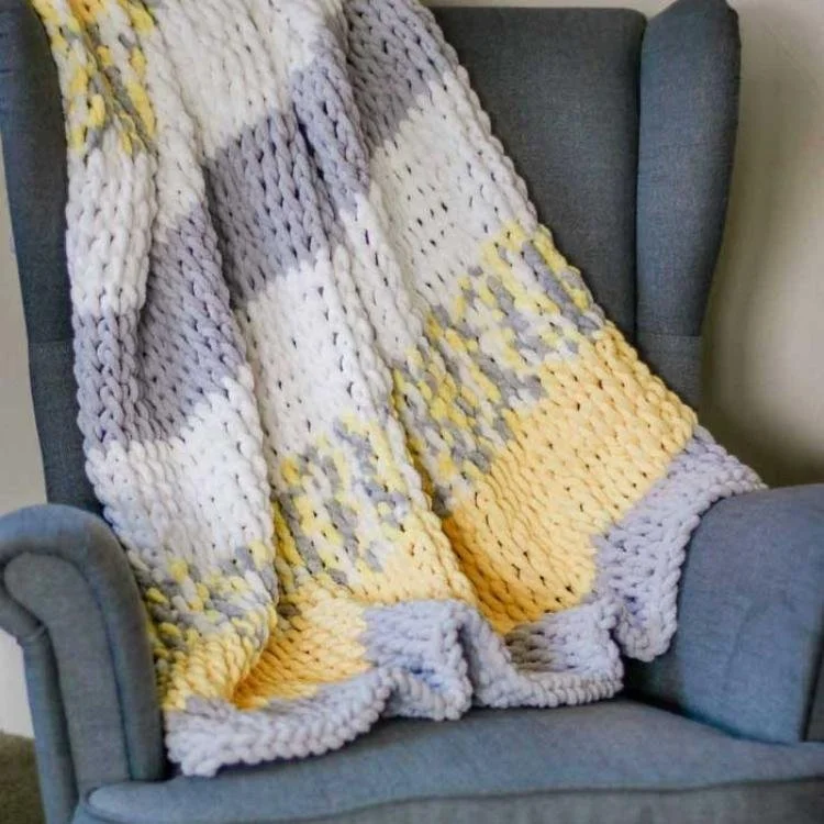 stripey knitted blanket draped on  armchair