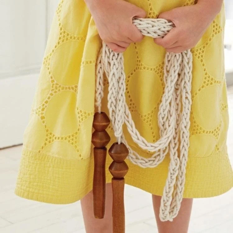 girl holding knitted skipping rope with wooden handles