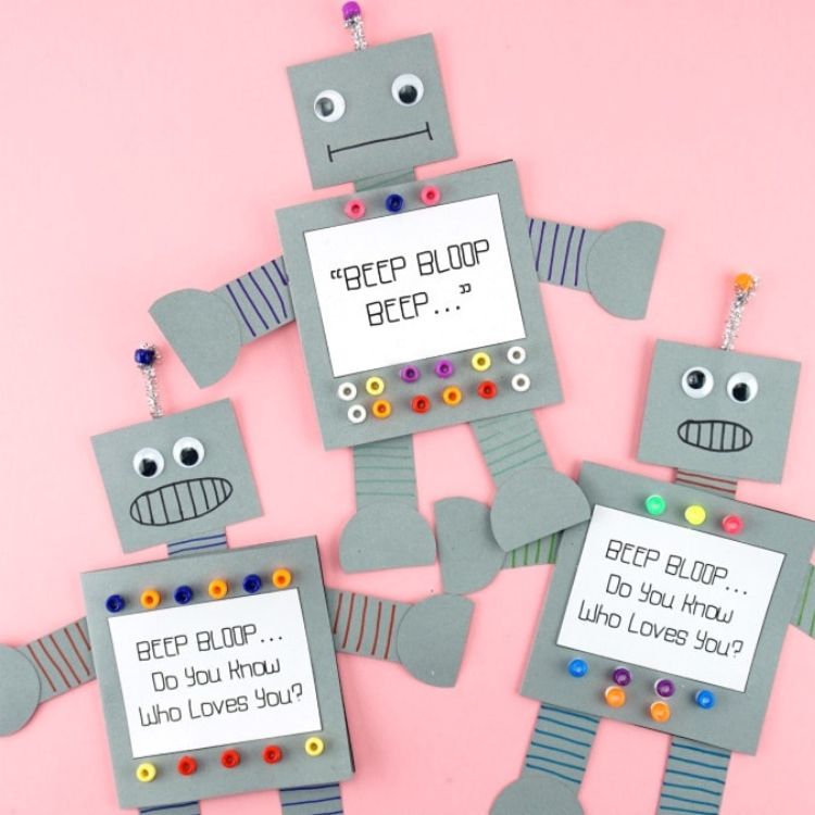 Grey robots shaped cards on pink background.