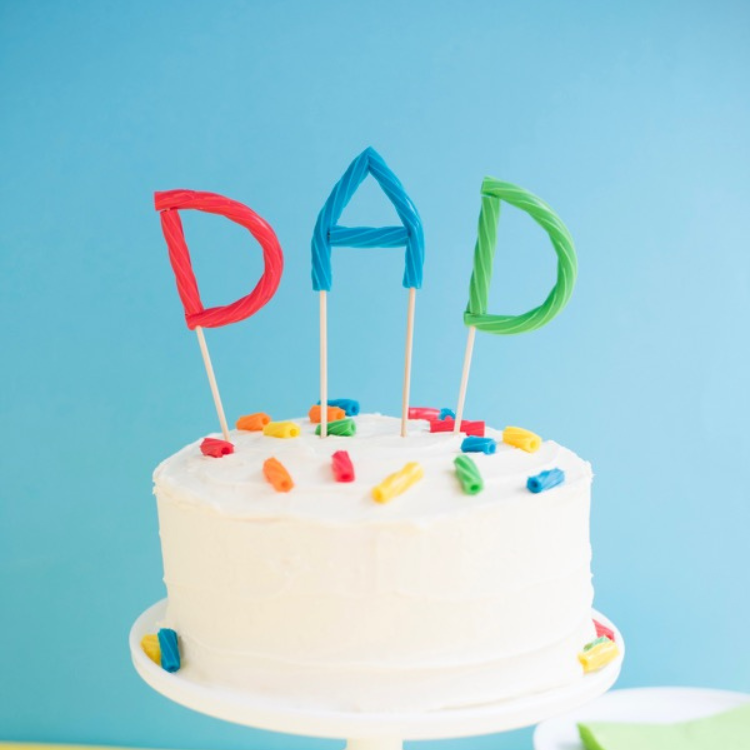 Letter cake topper spelling Dad.