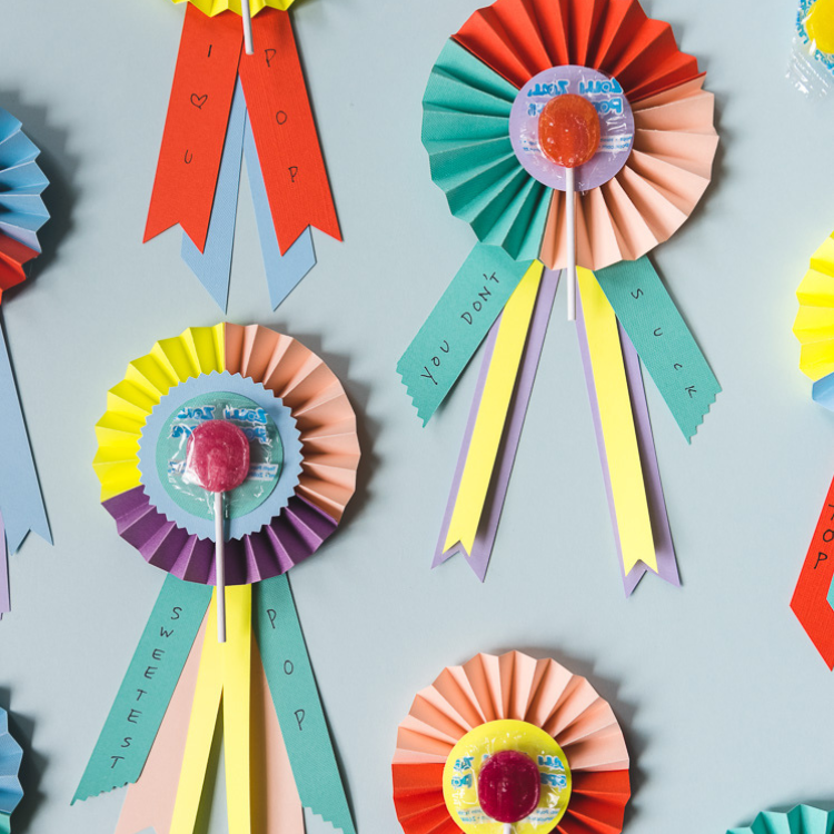 Paper rosettes with lollipops attached.