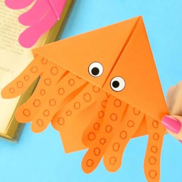 Orange origami conner bookmark in the shape of an octopus.