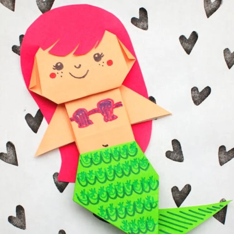 Origami mermaid with red hair and green tail.