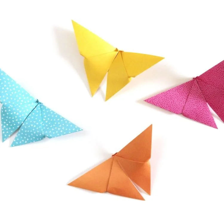 Origami paper butterflies on white background.