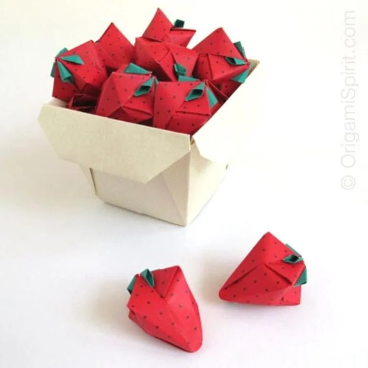 Origami strawberries in paper punnet.