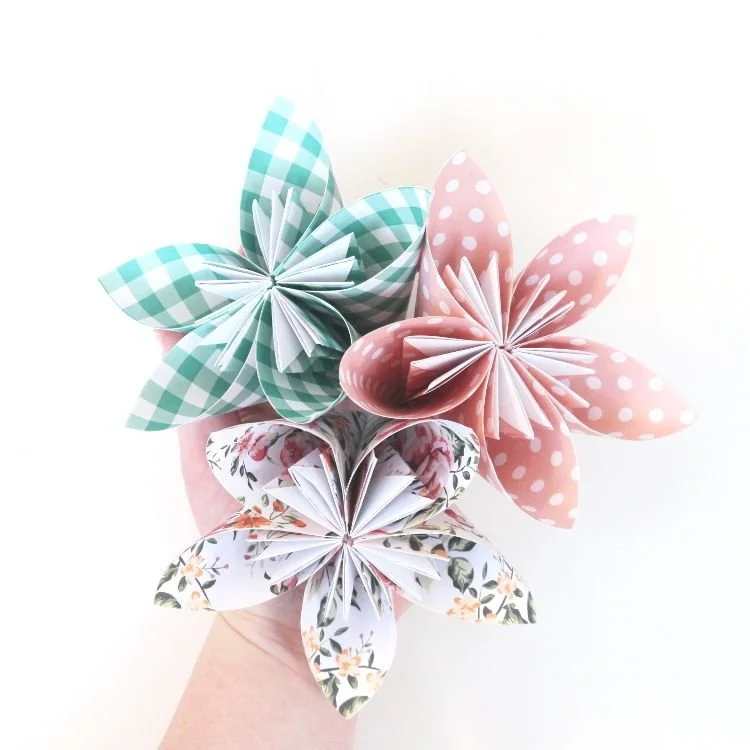 Hand holding origami flowers.