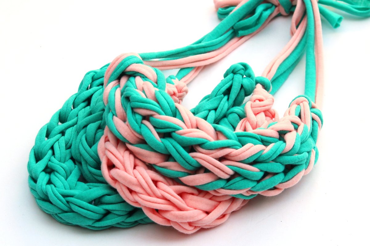 Close up of pink and turquoise finger knitted t-shirt yarn.
