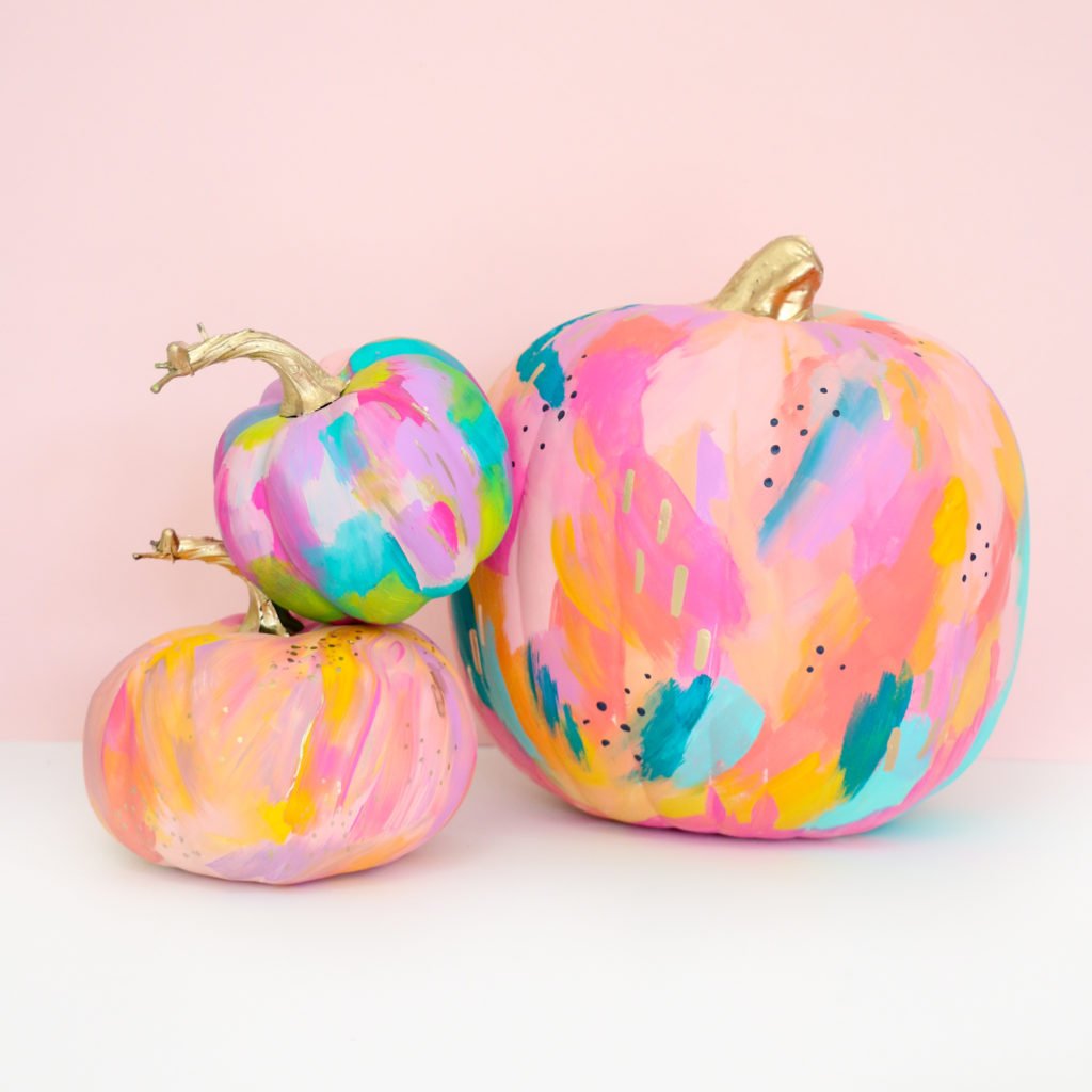 Three pumpkins covered in abstract painted brushstrokes.