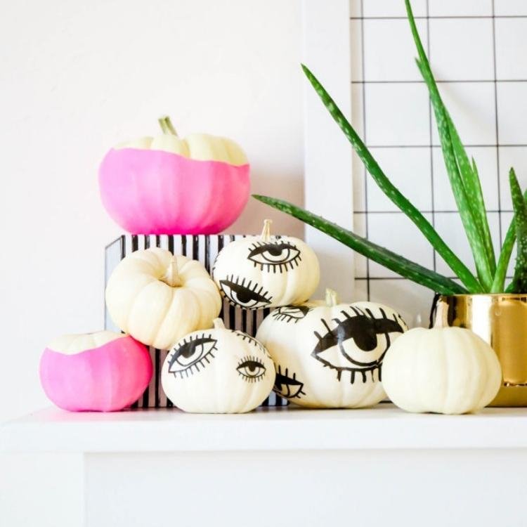 White pumpkins with black eye decorations.