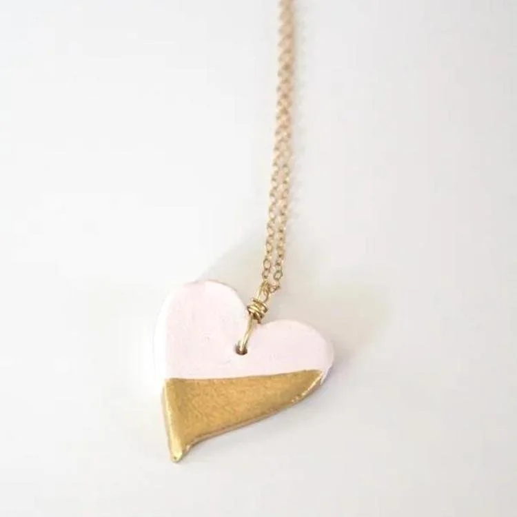 Half gold and half pink heart on gold chain.