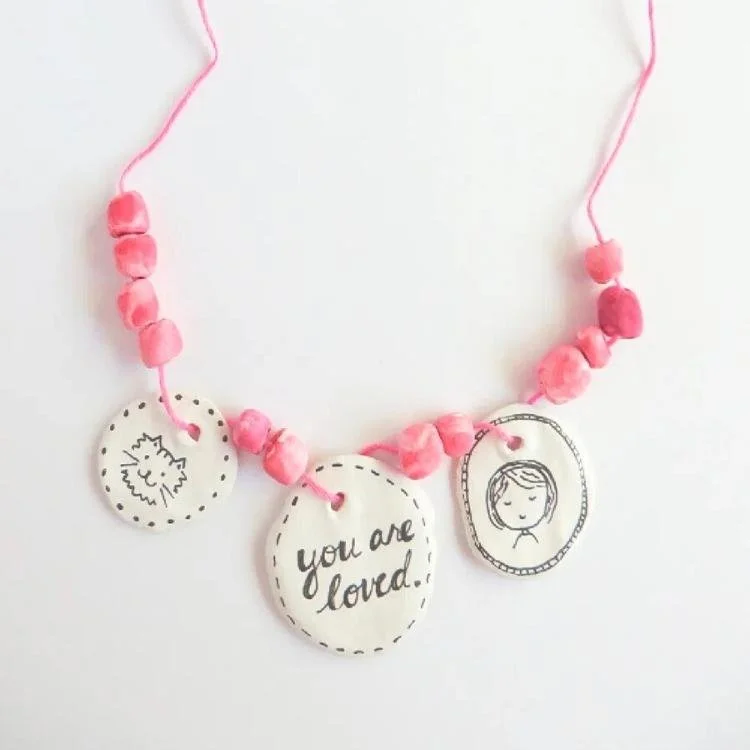 Pink beaded necklace with black and white pendants.