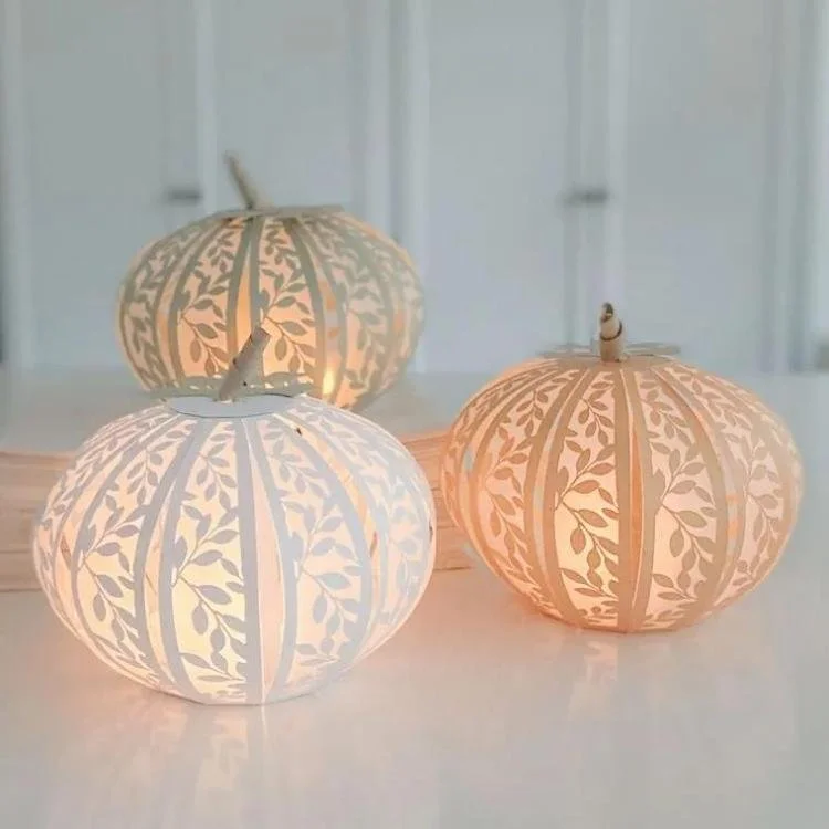 3 lit up paper pumpkins lanterns.