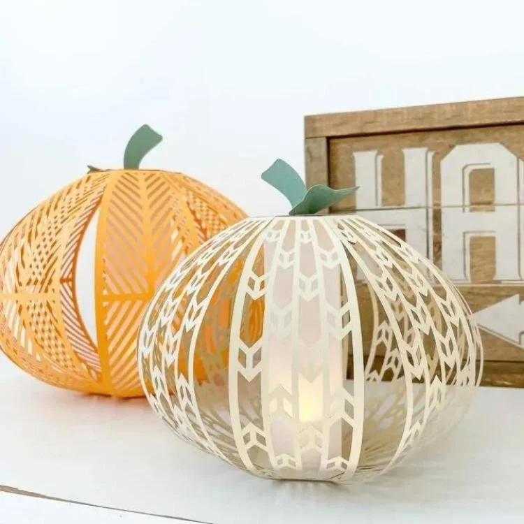 Paper pumpkin lanterns lit up with tea light.
