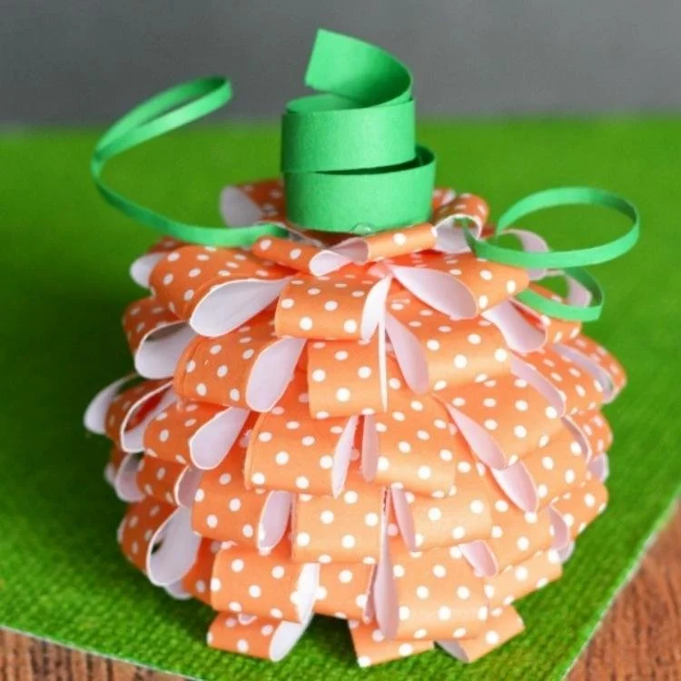 Paper pumpkin made out of folded paper strips.