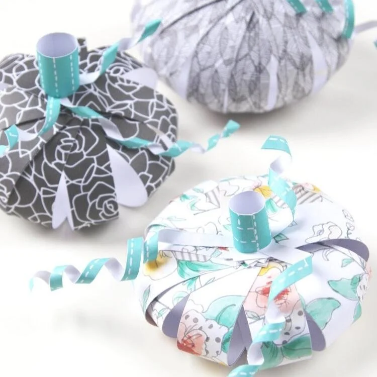 Paper pumpkins made out of scrapbook paper.