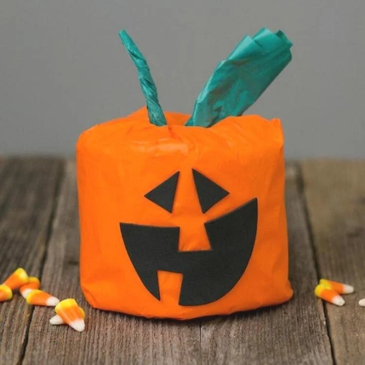 Toilet paper roll decorated to look like pumpkin.