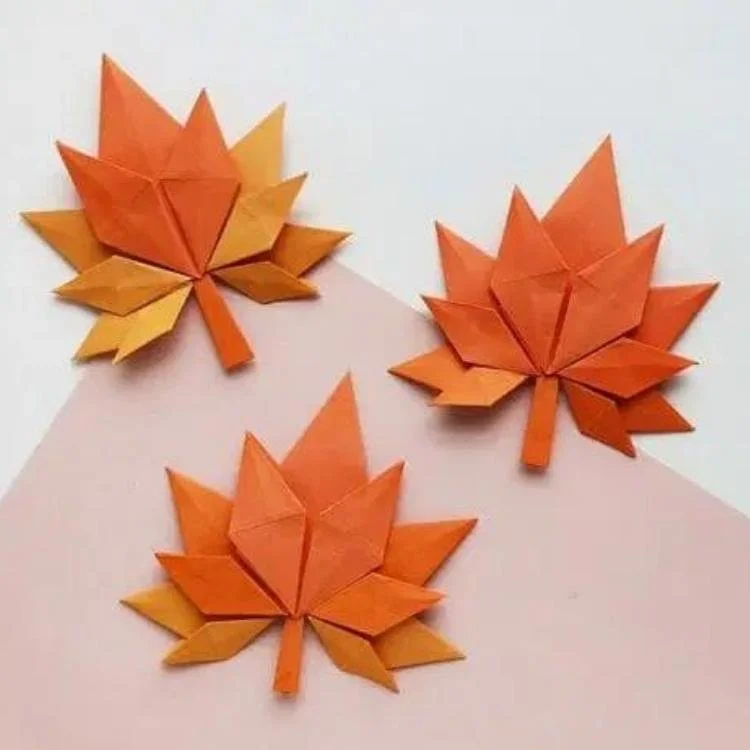 Orange origami maple leaves.