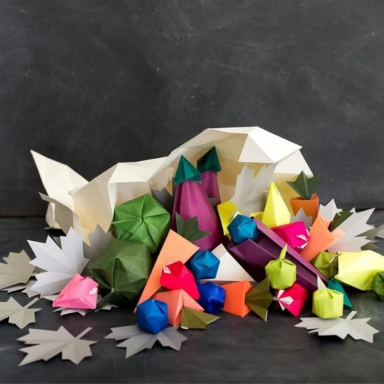 Origami cornucopia with paper fruit and vegtables.